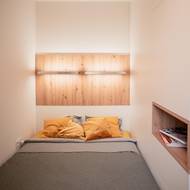 Úložné prostory jsou i ve stěně u postele