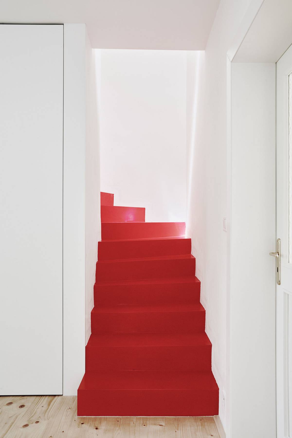 Se zbytkem interiéru kontrastuje schodiště upravené červenou stěrkou