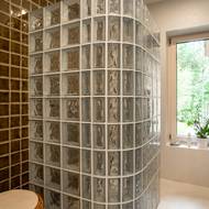 Zaoblený sprchový kout je tvořený skleněnými tvárnicemi.