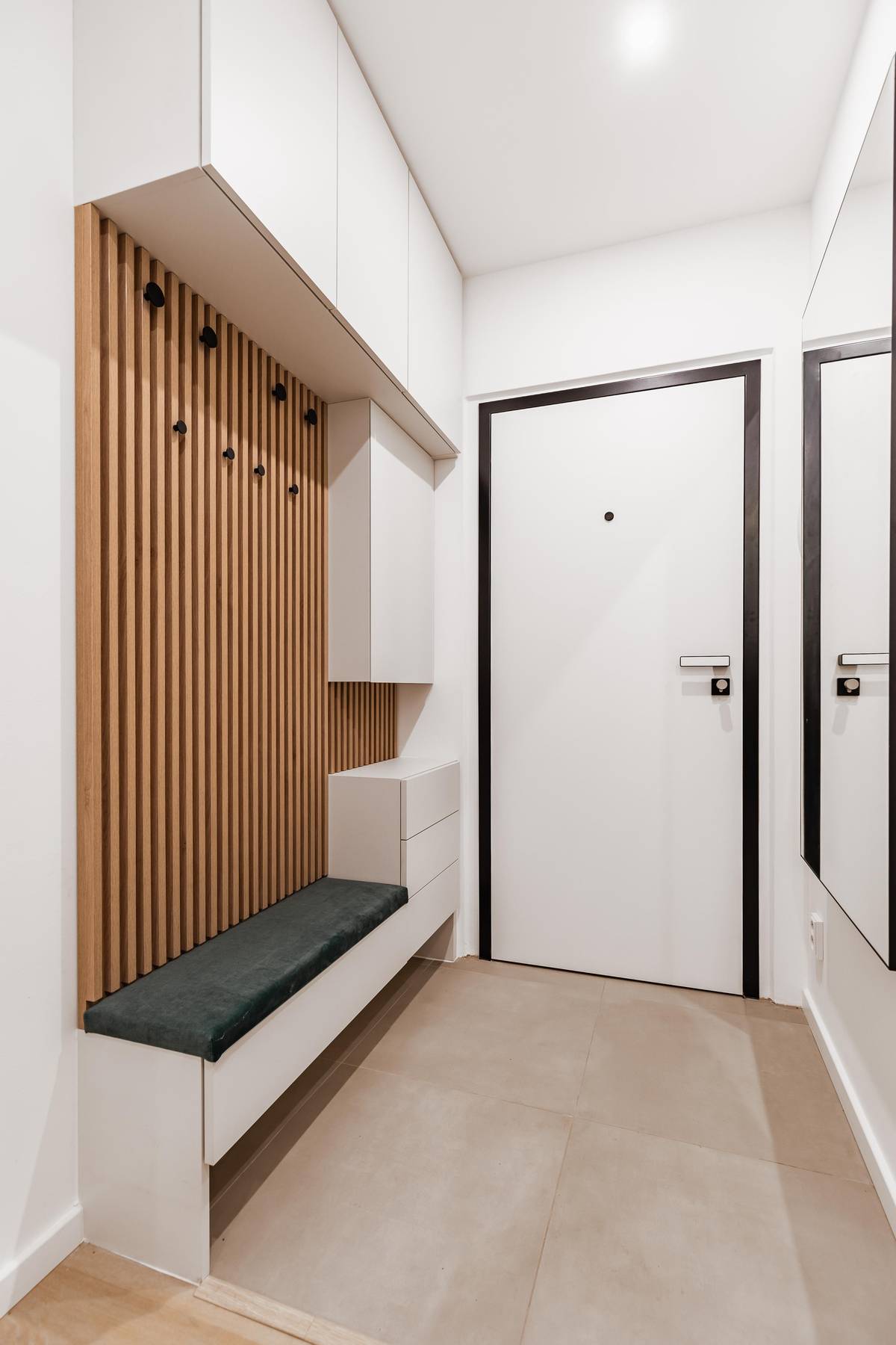 V předsíni je dlažba a úložná sestava s lavicí vyrobená na míru